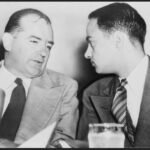 Sen. Joseph McCarthy (left) chats with his attorney Roy Cohn during Senate subcommittee hearings on the McCarthy-Army dispute. United Press International telephoto. United States Library of Congress digital ID cph.3c14995, Public Domain.