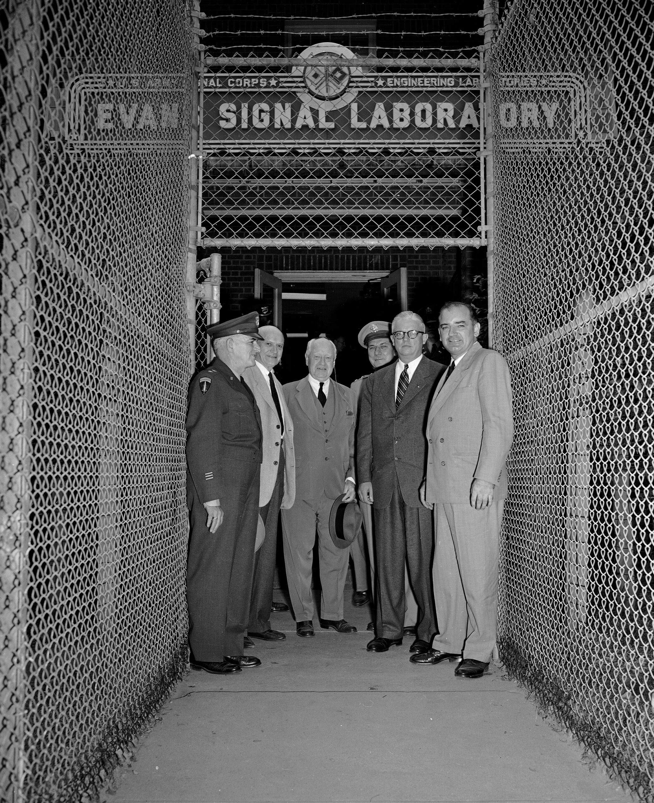 Sen. Joe McCarthy, right, Secretary of Army Robert T. Stevens, second from right, and New Jersey congressmen leave the Evans Signal Laboratory at Fort Monmouth, N.J., Oct. 20, 1953, where they had been investigating possible security leaks at the Army Signal Corps Radar Laboratories.  At the gate are, left to right: Maj. Gen. Kirke B. Lawton; Sen. H. Alexander Smith (R-N.J.); Rep. James C. Auchincloss (R-N.J.); Maj. Gen. George I. Back, chief of the Army Signal Corps; Stevens and McCarthy.  McCarthy told newsmen he hopes to find new leads for purported spy ring operating  within the radar center.  (AP Photo)
