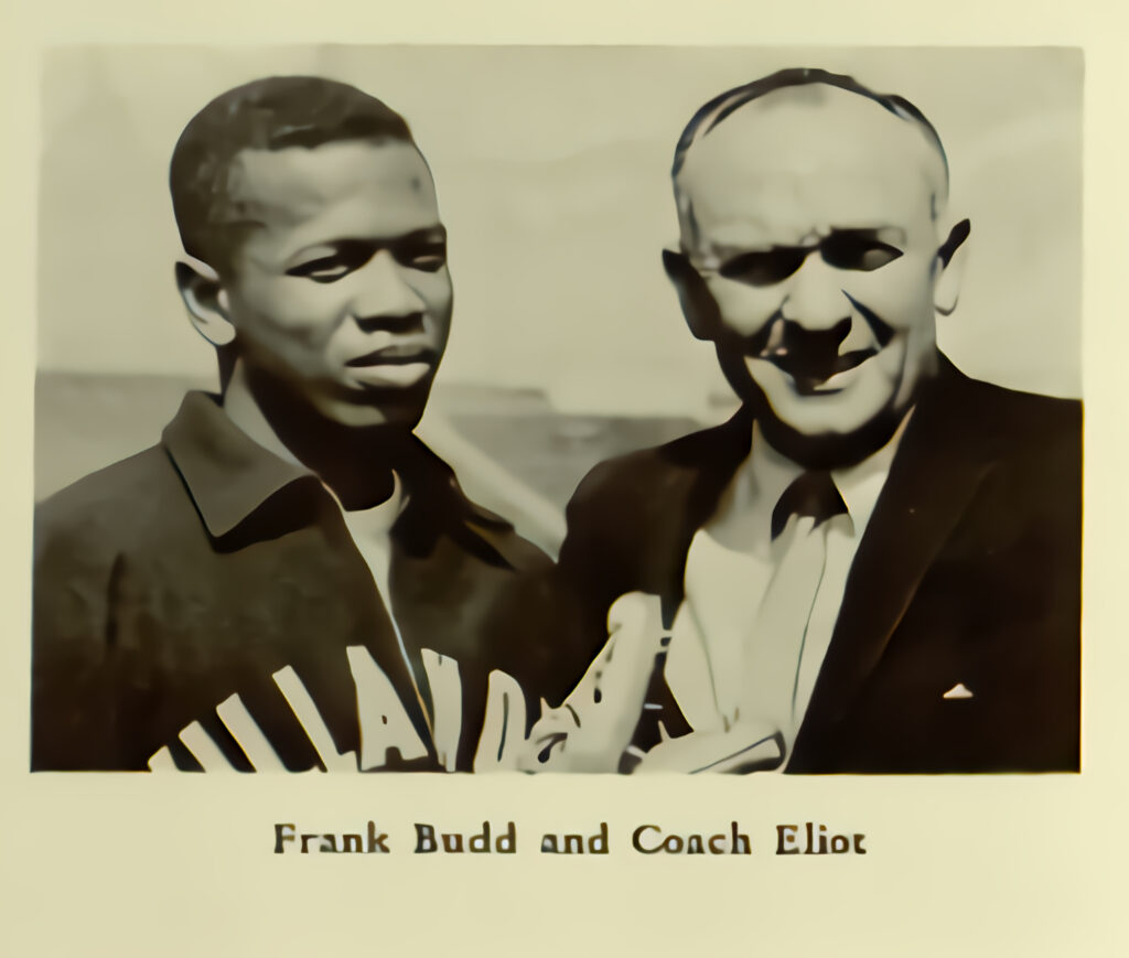 Image: Photograph of Frank Budd with Jumbo Elli0tt. Caption:   James F. "Jumbo" Elliott (August 8, 1915 – March 22, 1981) was an American track and field coach considered one of the greatest of all time. His Villanova University teams won eight national collegiate team titles; his athletes won 82 NCAA championships, set 66 world records, and won five Olympic gold medals. Image from The Belle Air 1962, Villanova University Yearbook. Image © Digital Library@Villanova University.