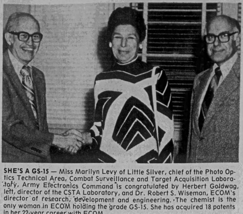 Newspaper clipping from the Red Bank Register showing Fort Monmouth civilian chemist Marilyn Levy being congratulated on achieving GS-15 status. News clip courtesy Newspapers.com, used with permission.