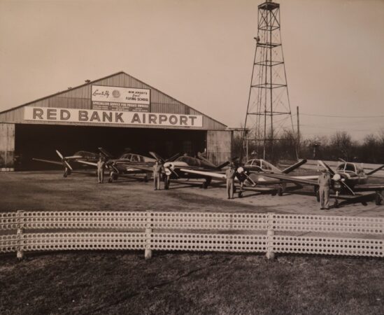 Photo of Red Bank Airport Air Taxi pilots and planes posed in front of their hangar. Image credit: Dorn's Classic Images, John R. Barrows personal collection.